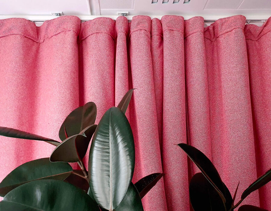 Rideau acoustique rose épais avec plante verte en premier plan, intérieur moderne